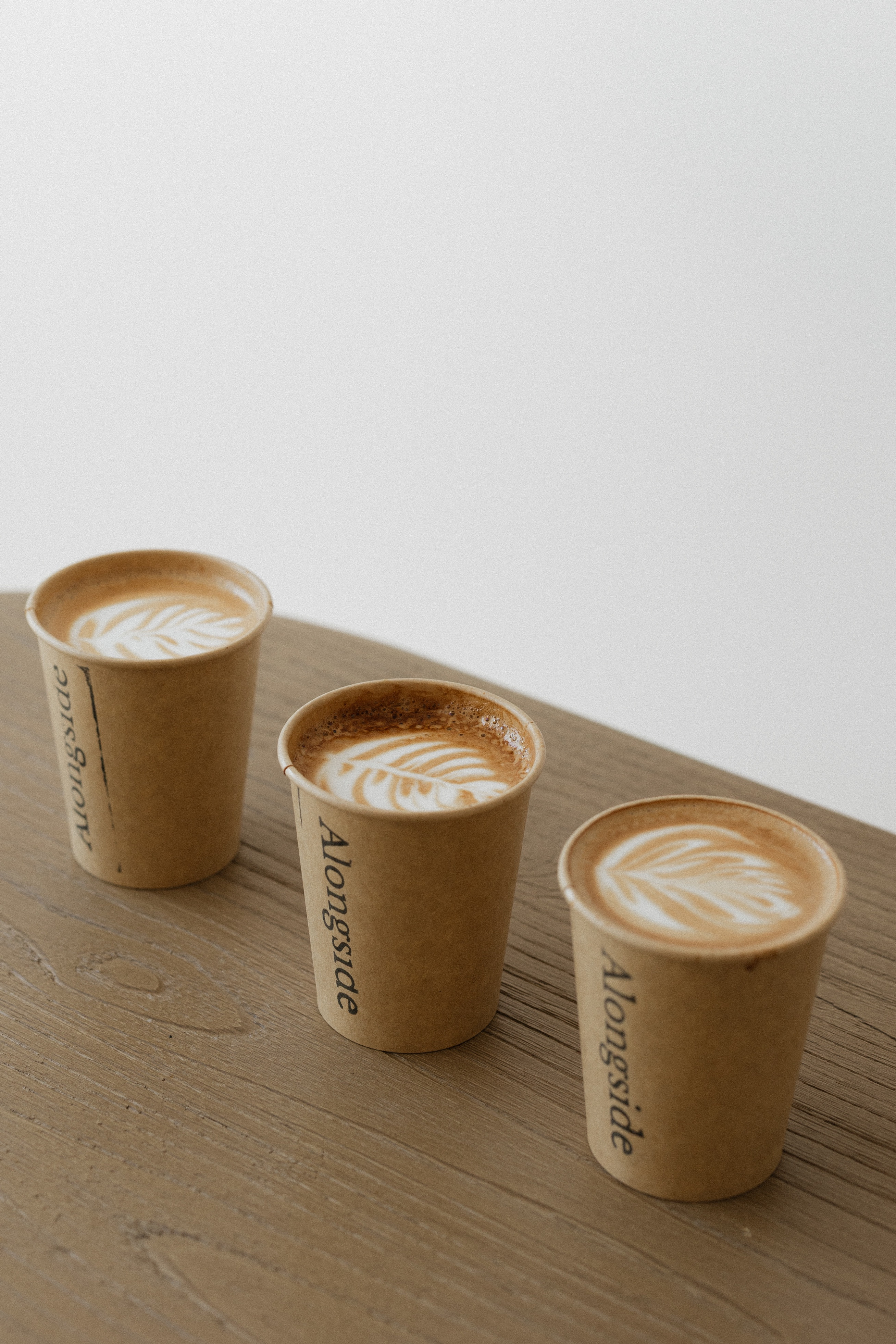 Alongside Coffee cups with latte art